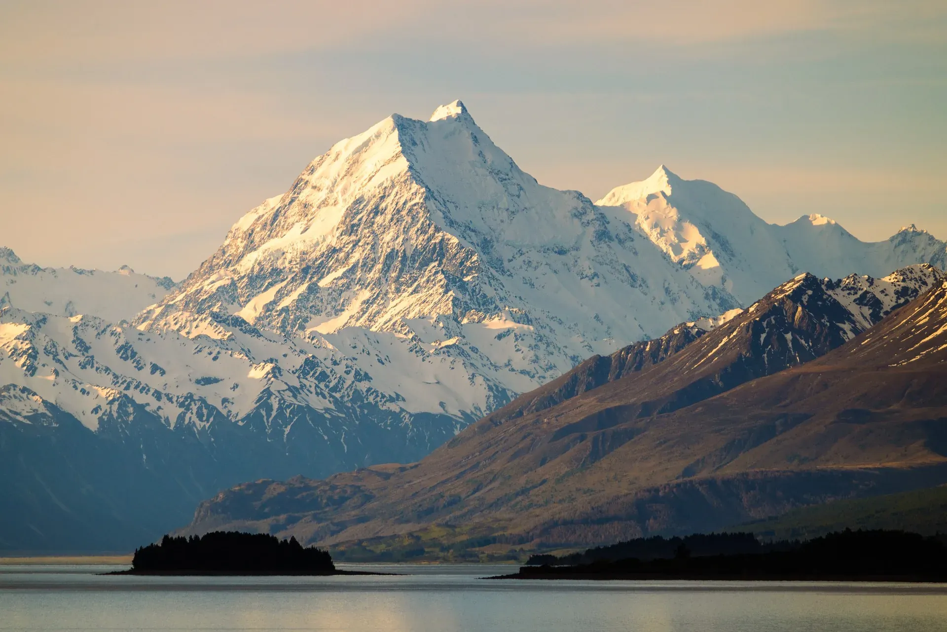 Aoraki Mount Cook at sunrise above a calm lake.